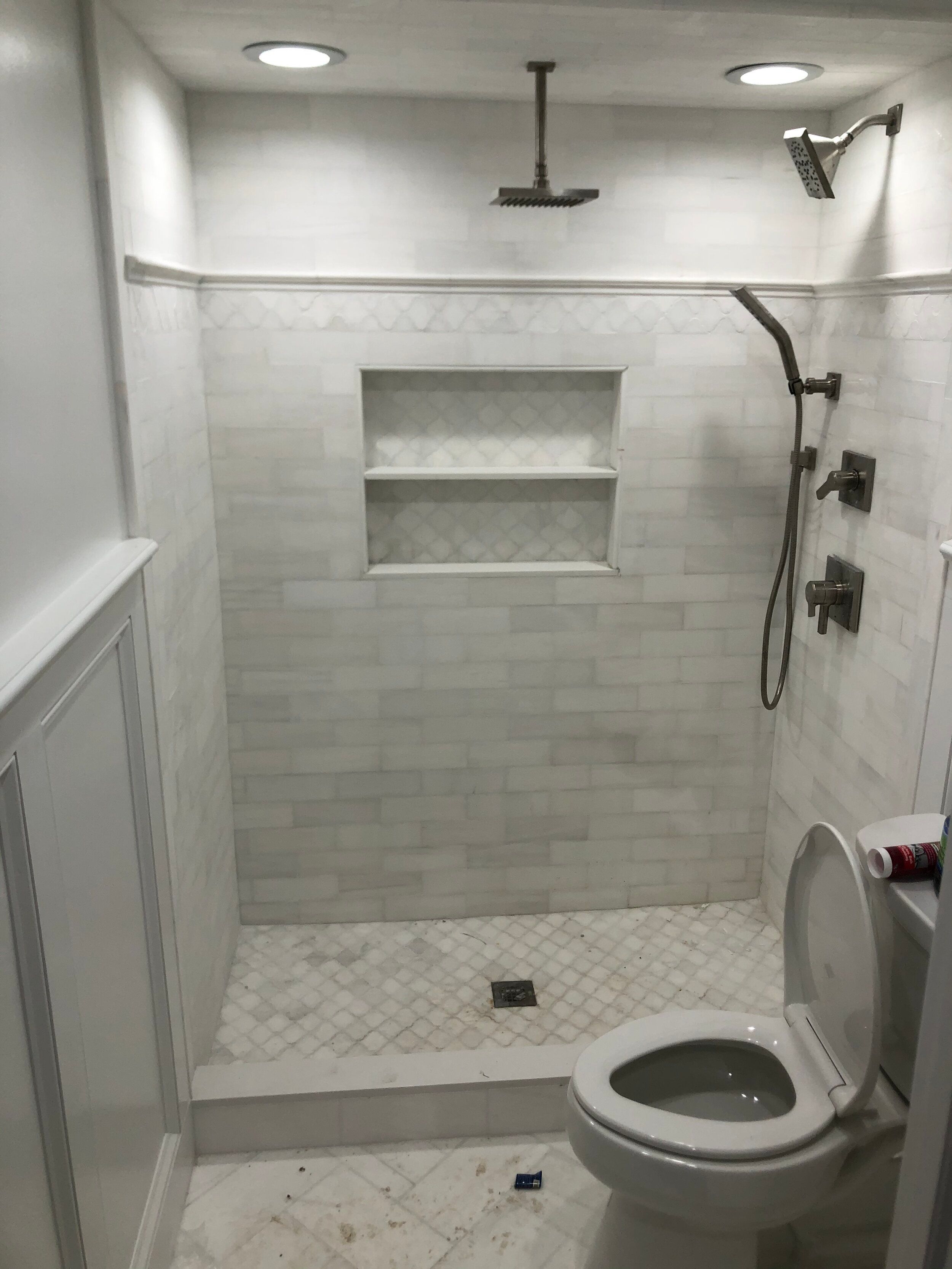 Remodeled bathroom walk-in shower with gray tile walls, a tiled niche and a ceiling-mounted rain shower head
