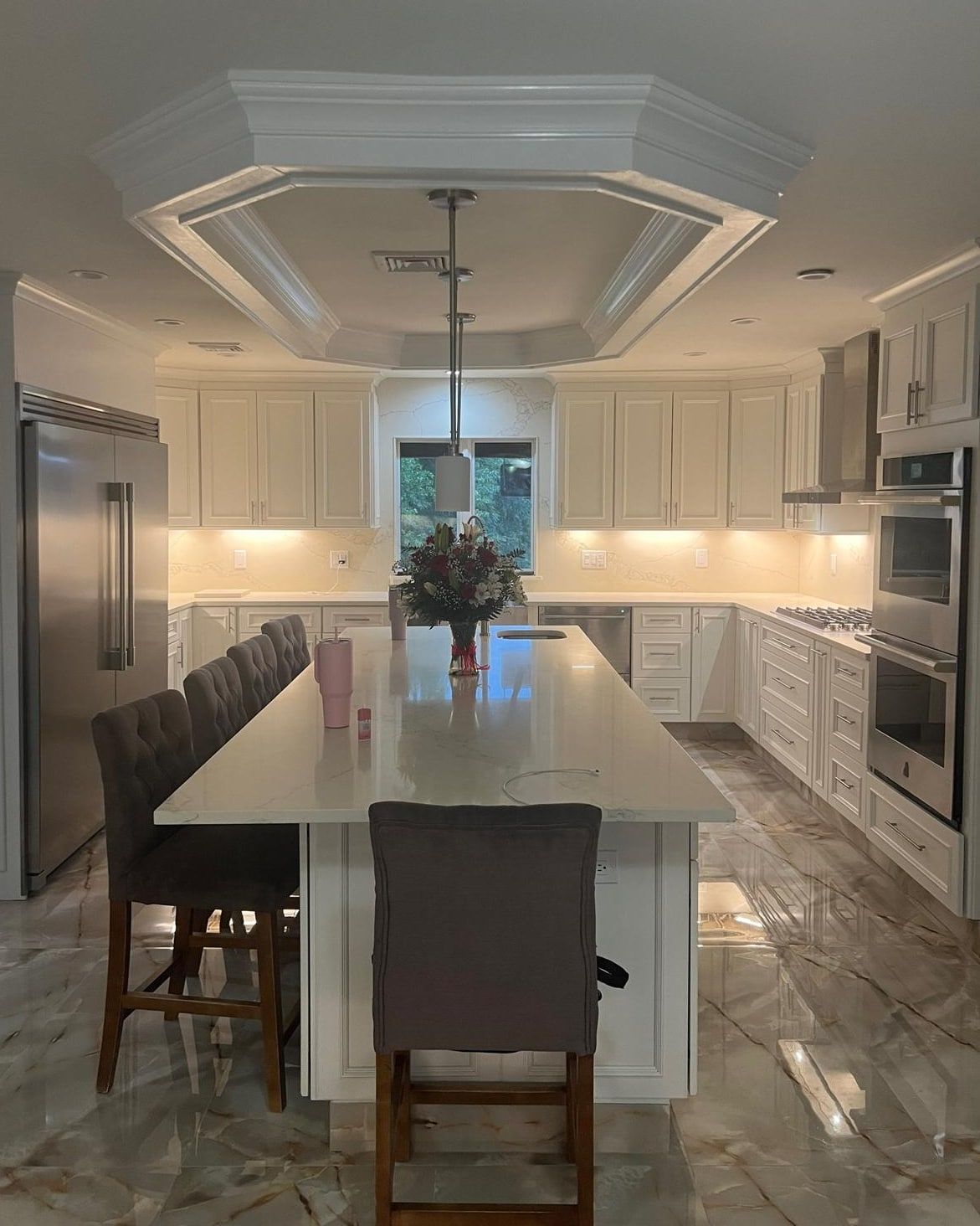 Finished Clifton, NJ kitchen with white cabinets, a quartz island and an octagonal tray ceiling