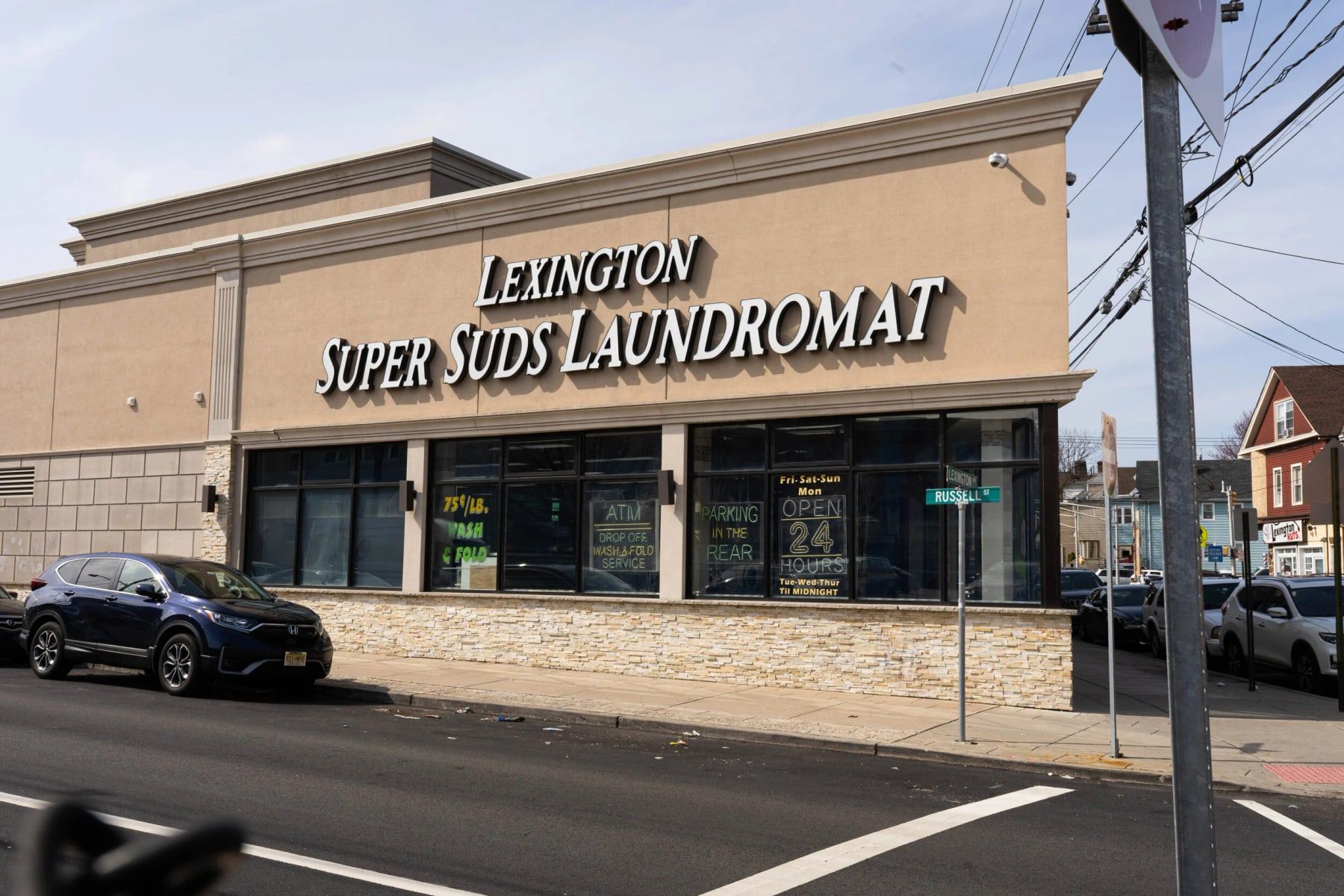 Commercial building built by Omar Construction in New Jersey: a laundromat with a stucco facade, a stacked-stone base and large storefront windows