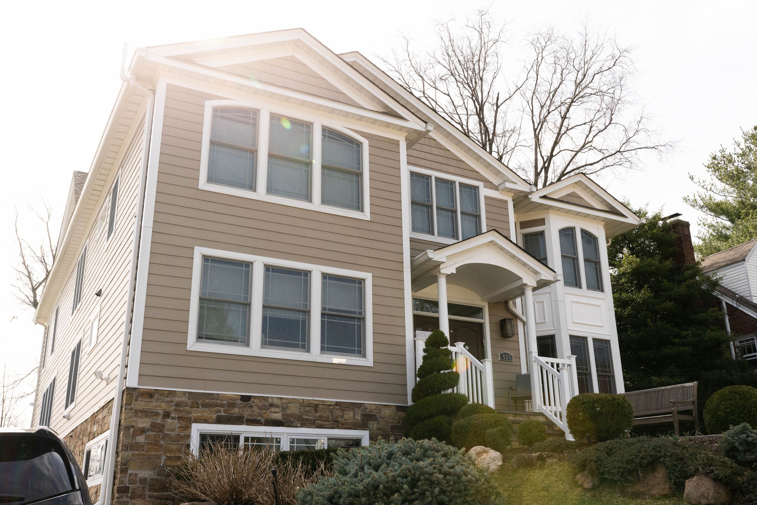 Home with beige siding and a stone base, built by Omar Construction