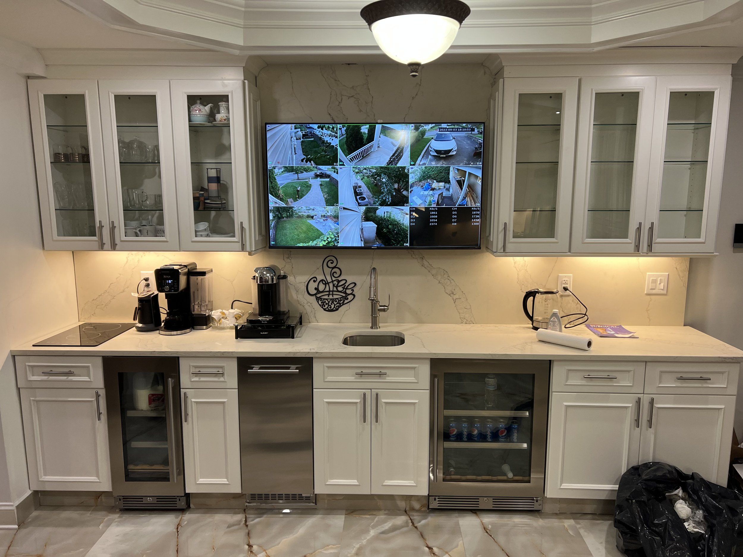 Remodeled kitchen coffee bar with white shaker cabinets, glass-front upper cabinets, a wine fridge and a quartz countertop