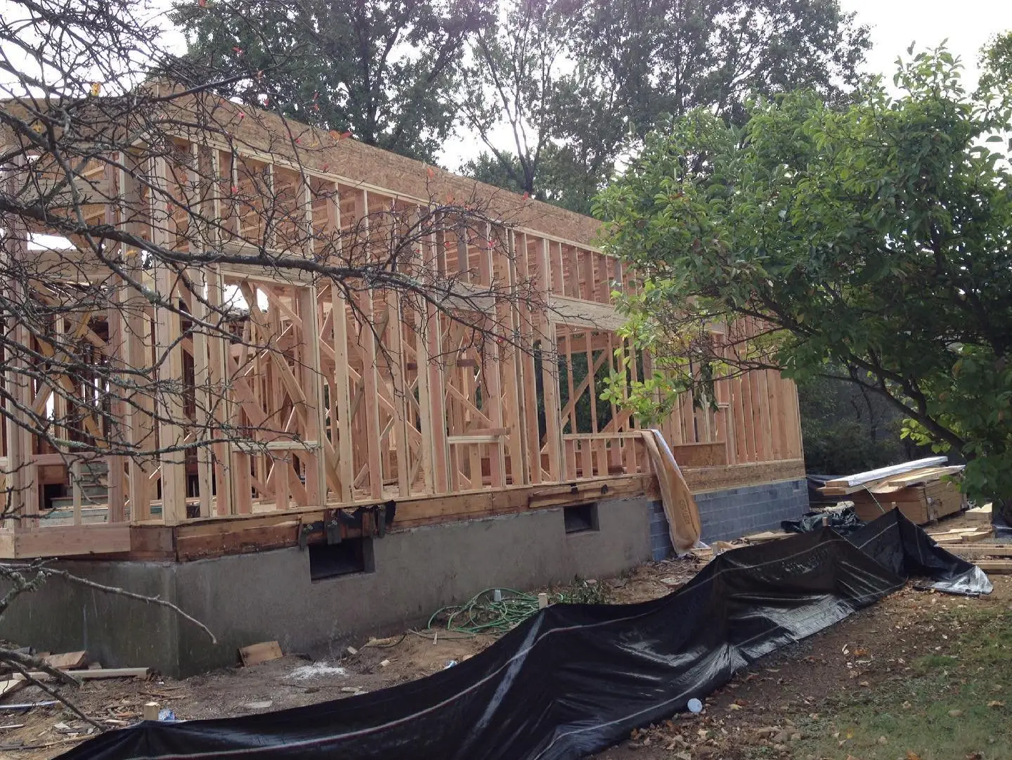 Side view of a new home framing with house wrap going up in New Jersey