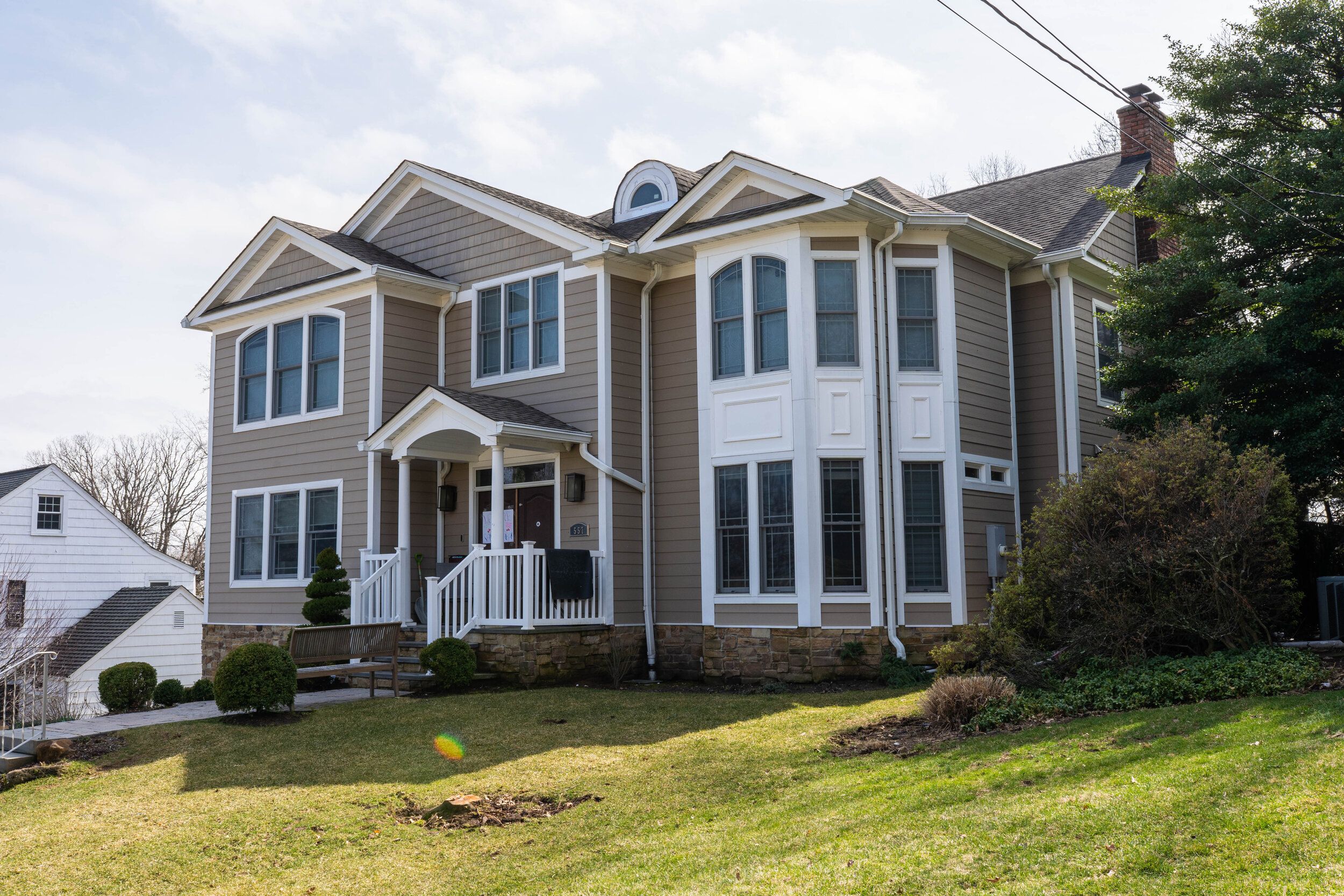 Two-story home with gray siding and bay windows built by Omar Construction